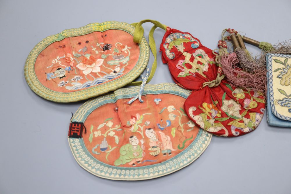 A collection of five Chinese embroidered purses, a red silk applique worked purse with silk tassels, finely embroidered petit point pur